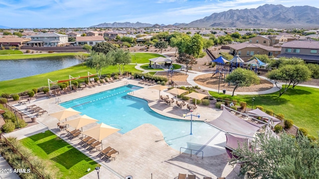 community pool with a residential view, a patio, and a water and mountain view