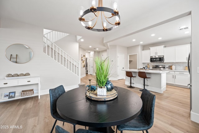 dining area featuring recessed lighting, visible vents, light wood-style flooring, baseboards, and stairs