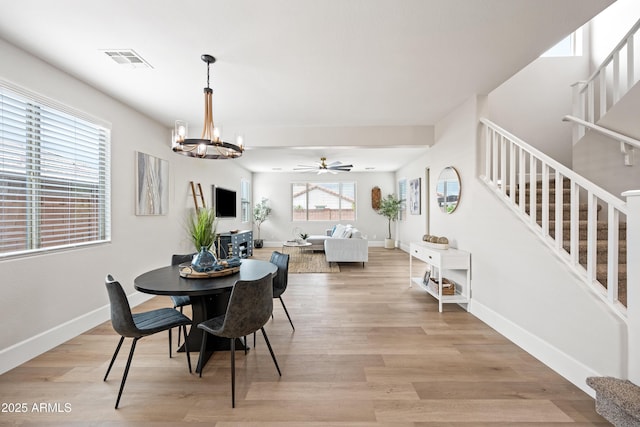 dining area with stairway, light wood-style flooring, visible vents, and baseboards