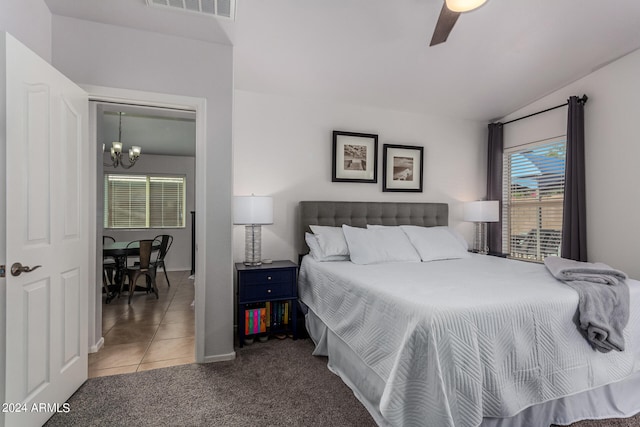 carpeted bedroom with ceiling fan with notable chandelier