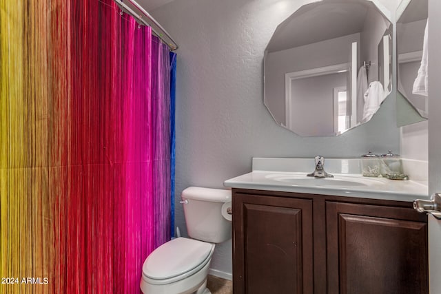 bathroom featuring walk in shower, vanity, and toilet