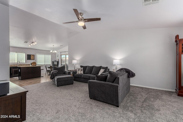 carpeted living room featuring ceiling fan with notable chandelier, lofted ceiling, and sink