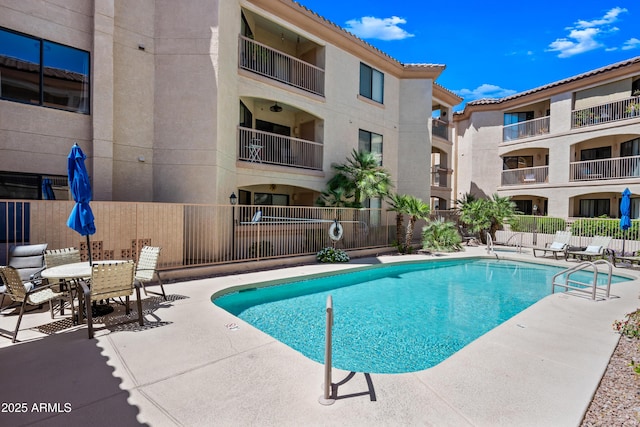 community pool featuring a patio and fence