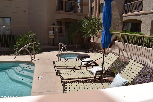 view of pool featuring a patio, a swimming pool, a hot tub, and fence