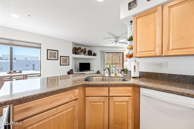 kitchen featuring light brown cabinetry, plenty of natural light, a sink, and dishwasher