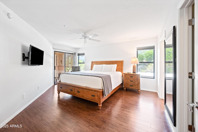 bedroom featuring baseboards, multiple windows, a ceiling fan, and wood finished floors