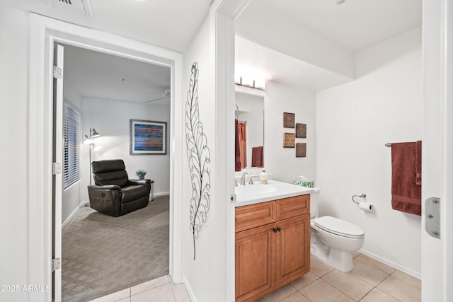 bathroom featuring ceiling fan, vanity, toilet, tile patterned floors, and baseboards