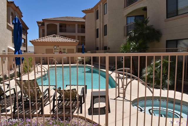 pool with a patio and fence