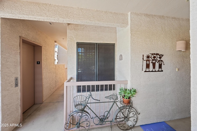 entrance to property with elevator and stucco siding