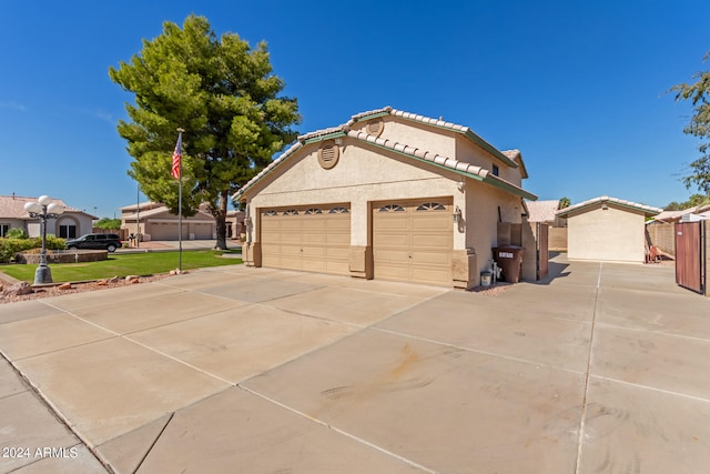 view of side of property with a lawn and a garage