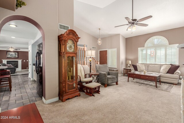 carpeted living room featuring high vaulted ceiling and ceiling fan