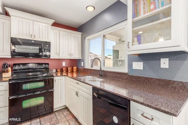 kitchen with white cabinets, black appliances, sink, and dark stone counters