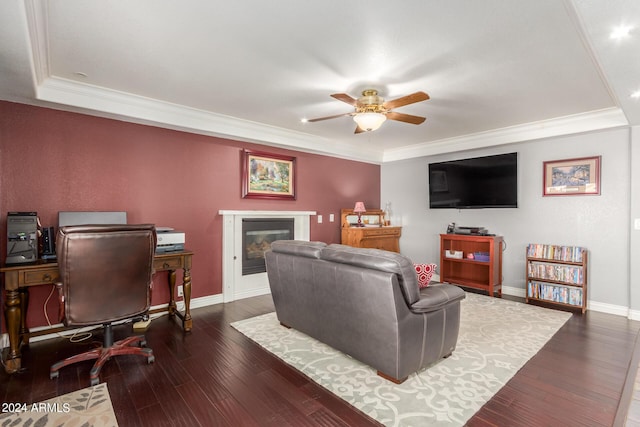 living area with wood-type flooring, a ceiling fan, baseboards, and a glass covered fireplace