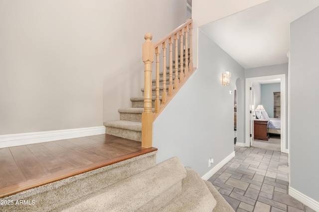 stairs with baseboards and stone finish flooring