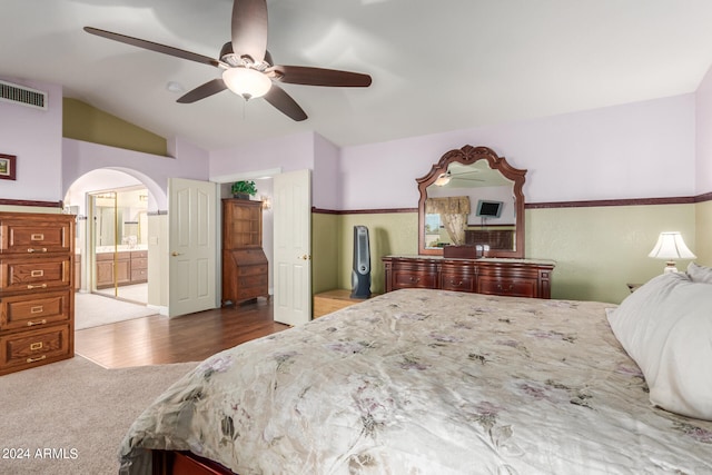 bedroom with vaulted ceiling, ensuite bathroom, light wood-type flooring, and ceiling fan