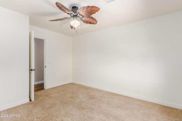 unfurnished room featuring baseboards, ceiling fan, and light colored carpet