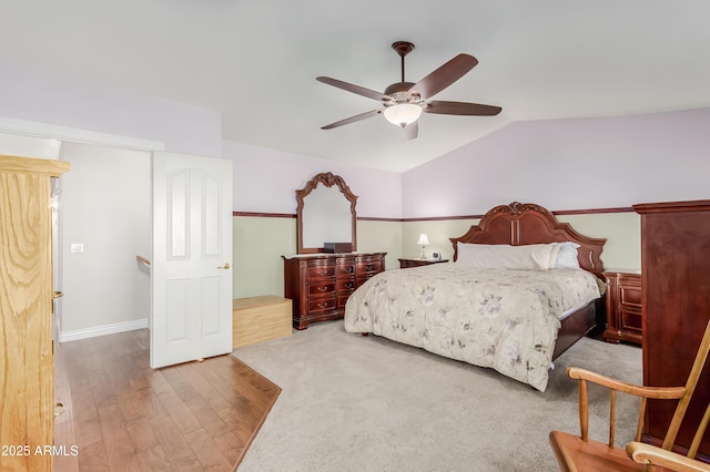 bedroom with ceiling fan, vaulted ceiling, and wood finished floors