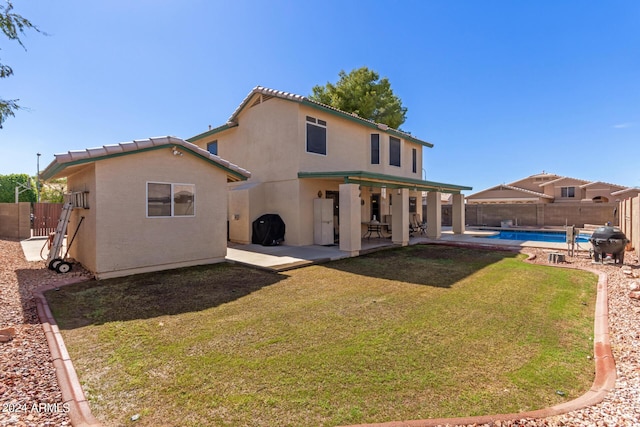 rear view of house featuring a lawn, a fenced in pool, a fenced backyard, and stucco siding