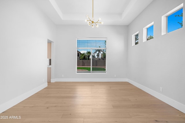 641 W Oriole Way, Chandler, AZ 85286 - unfurnished room with a raised ceiling, a chandelier, and light wood-type flooring
