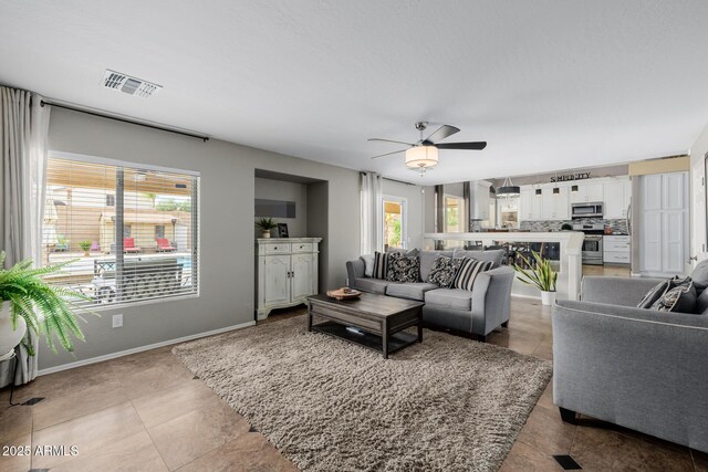 565 E Rosebud Dr, San Tan Valley, AZ 85143 - living room with visible vents, baseboards, light tile patterned flooring, and ceiling fan