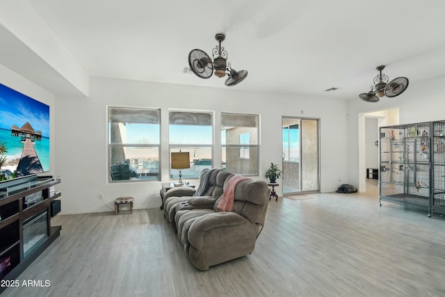 living room with an inviting chandelier and light wood-type flooring