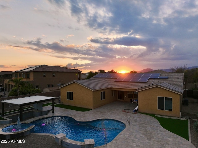 pool at dusk with a patio area