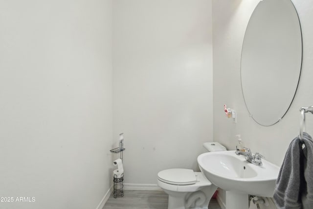 bathroom with hardwood / wood-style floors, sink, and toilet