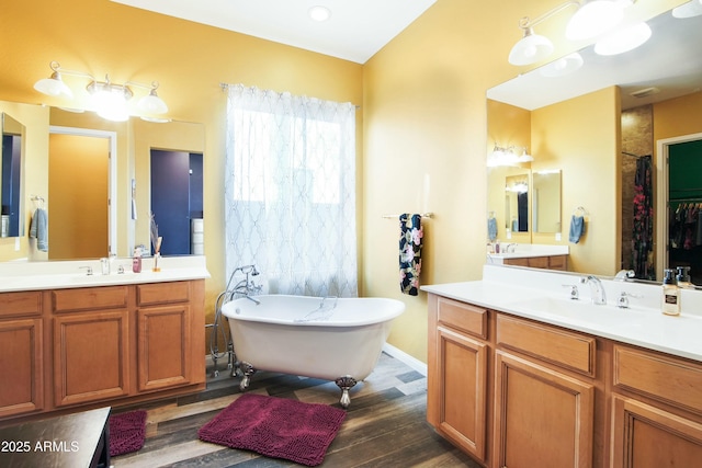 bathroom featuring vanity, hardwood / wood-style floors, and a bath