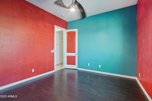 empty room with dark hardwood / wood-style floors and ceiling fan