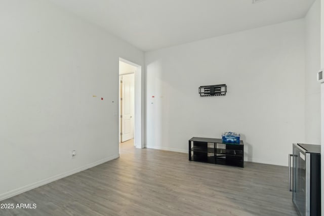 spare room featuring wine cooler and hardwood / wood-style floors