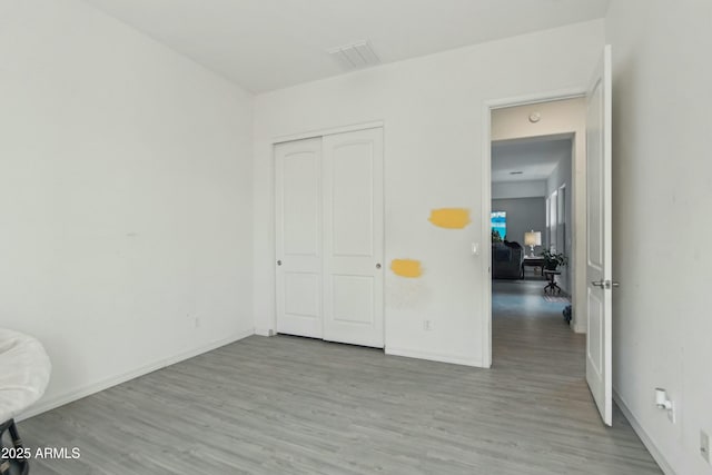 unfurnished bedroom with a closet and light wood-type flooring