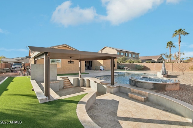 view of swimming pool with pool water feature, a hot tub, and a patio area