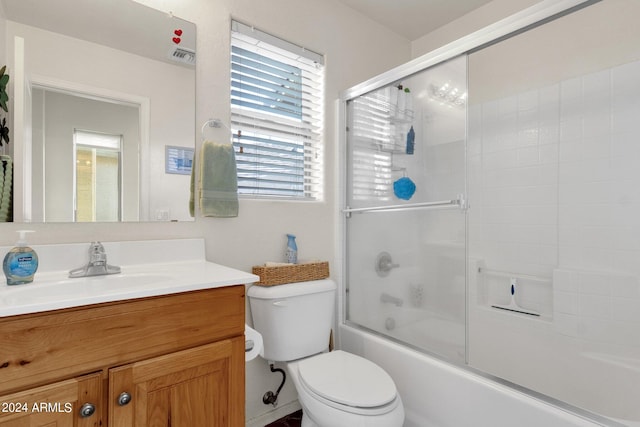 full bathroom featuring bath / shower combo with glass door, vanity, and toilet