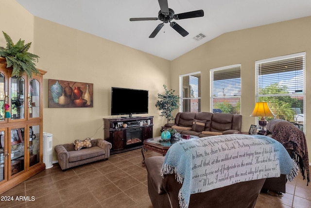 living room featuring dark tile patterned floors, vaulted ceiling, and ceiling fan