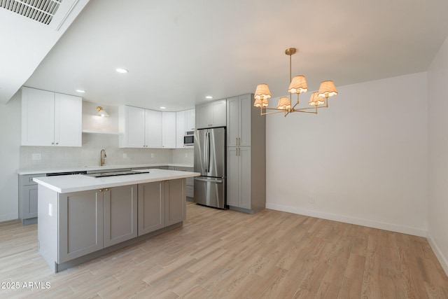 5132 N 83rd St, Scottsdale, AZ 85250 - kitchen with freestanding refrigerator, gray cabinets, light countertops, a center island, and a chandelier