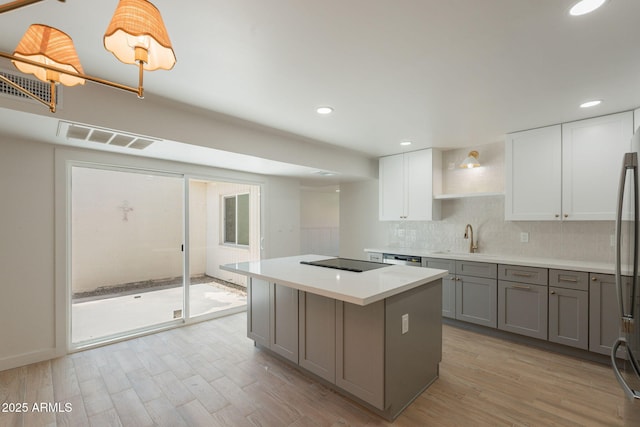 5132 N 83rd St, Scottsdale, AZ 85250 - kitchen with gray cabinetry, a sink, black electric stovetop, light wood-style flooring, and recessed lighting
