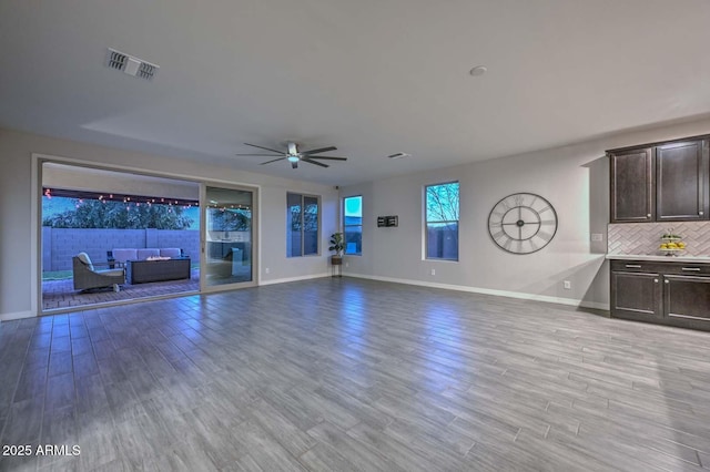 unfurnished living room featuring ceiling fan and light wood-type flooring