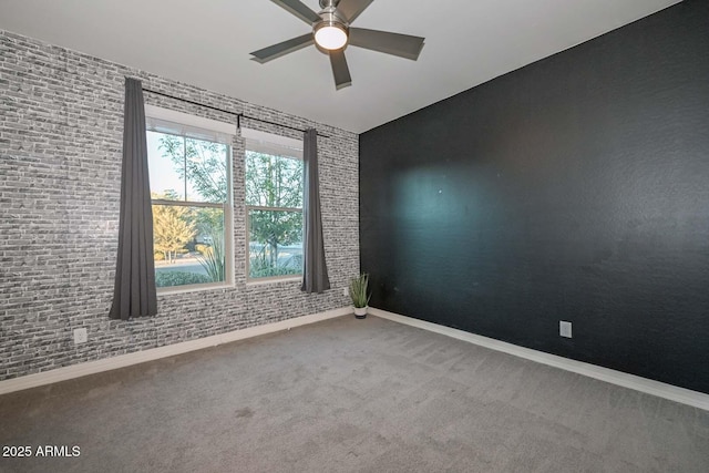 empty room with carpet, ceiling fan, and brick wall