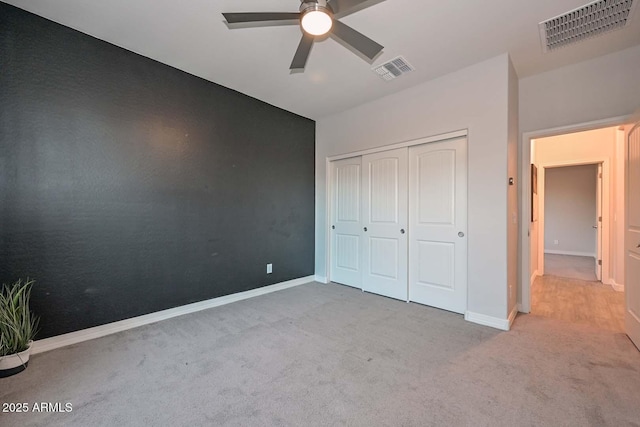 unfurnished bedroom with light colored carpet, a closet, and ceiling fan