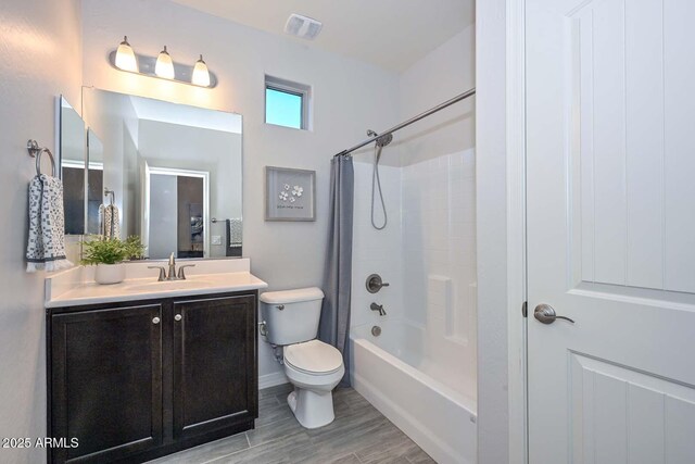 full bathroom featuring shower / bathtub combination with curtain, vanity, and toilet