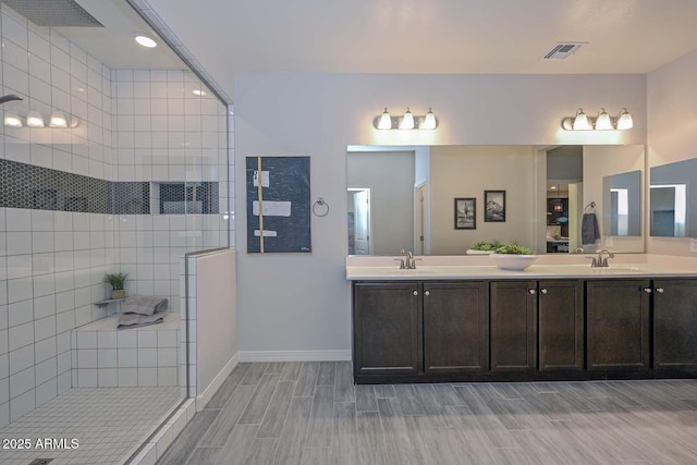 bathroom with vanity and a tile shower