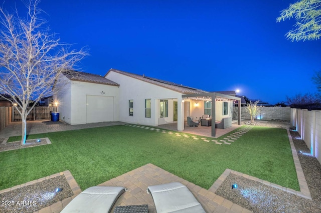 back house at twilight with a yard and a patio area