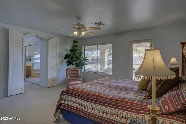 carpeted bedroom featuring ceiling fan and ensuite bath