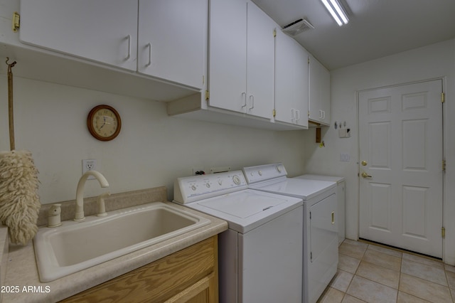 laundry area featuring cabinets, washer and dryer, sink, and light tile patterned floors