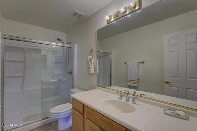 bathroom with tile patterned flooring, vanity, a shower with shower door, and toilet