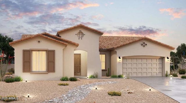 mediterranean / spanish house featuring stucco siding, driveway, a tiled roof, and a garage