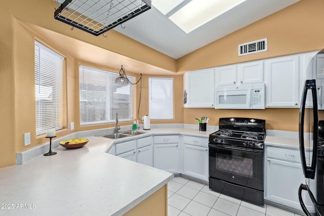 kitchen with visible vents, vaulted ceiling, light countertops, black appliances, and a sink