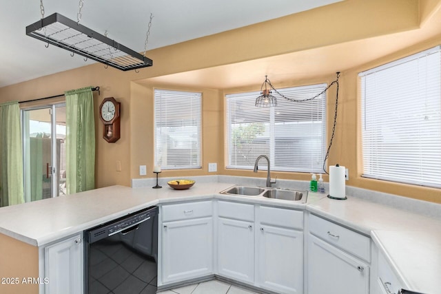 kitchen with black dishwasher, white cabinets, a peninsula, light countertops, and a sink