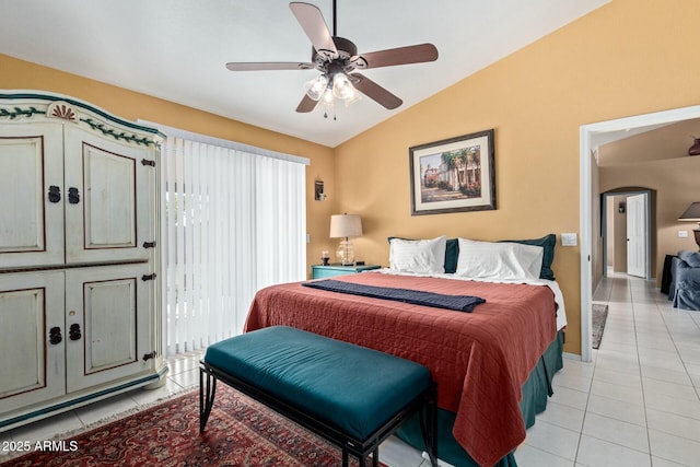 bedroom featuring light tile patterned floors, ceiling fan, arched walkways, baseboards, and vaulted ceiling