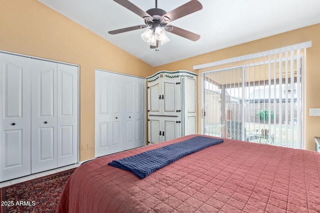 bedroom featuring a ceiling fan, vaulted ceiling, and multiple closets